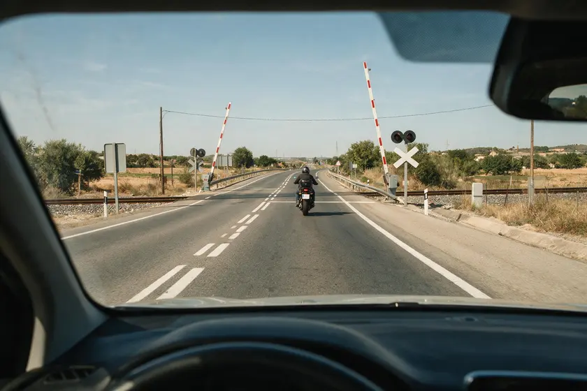 Motocicleta circulando en las proximidades de un paso a nivel