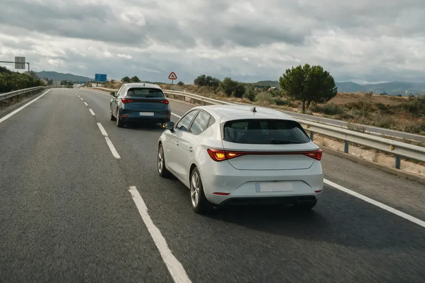 Coche cambiando al carril de la derecha con el intermitente puesto mientras otro ya circula por ese carril