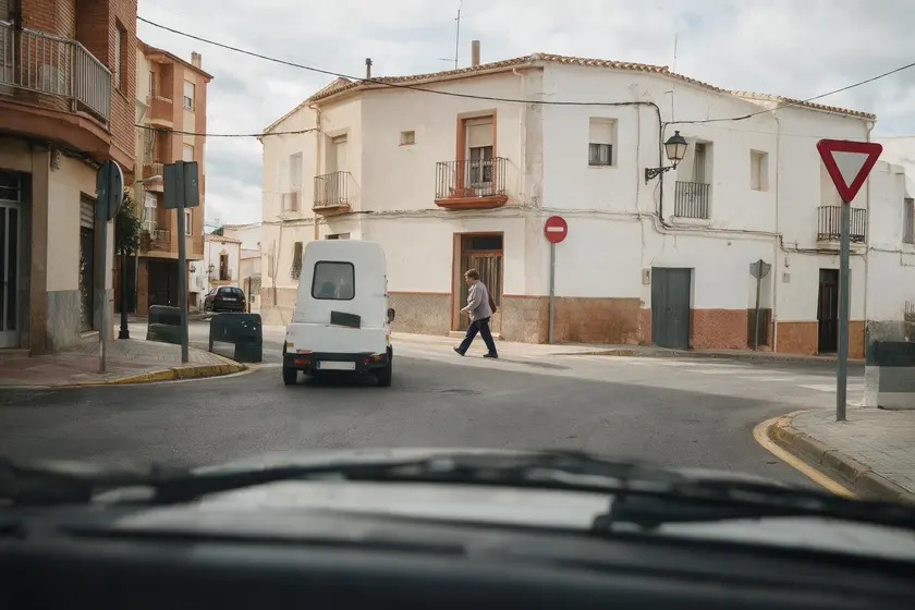 Coche cediendo el paso a un peatón que cruza al girar hacia otra vía