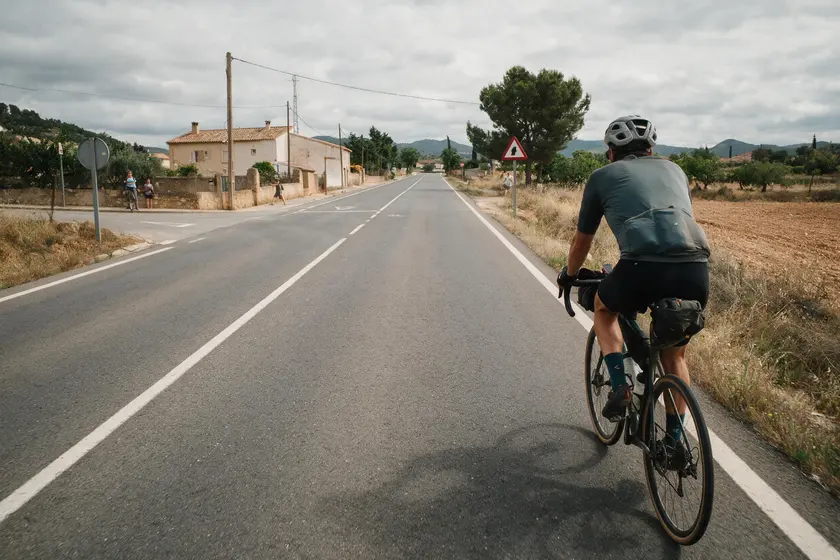 Ciclista situado a la derecha de la calzada antes de girar a la izquierda, sin carril habilitado