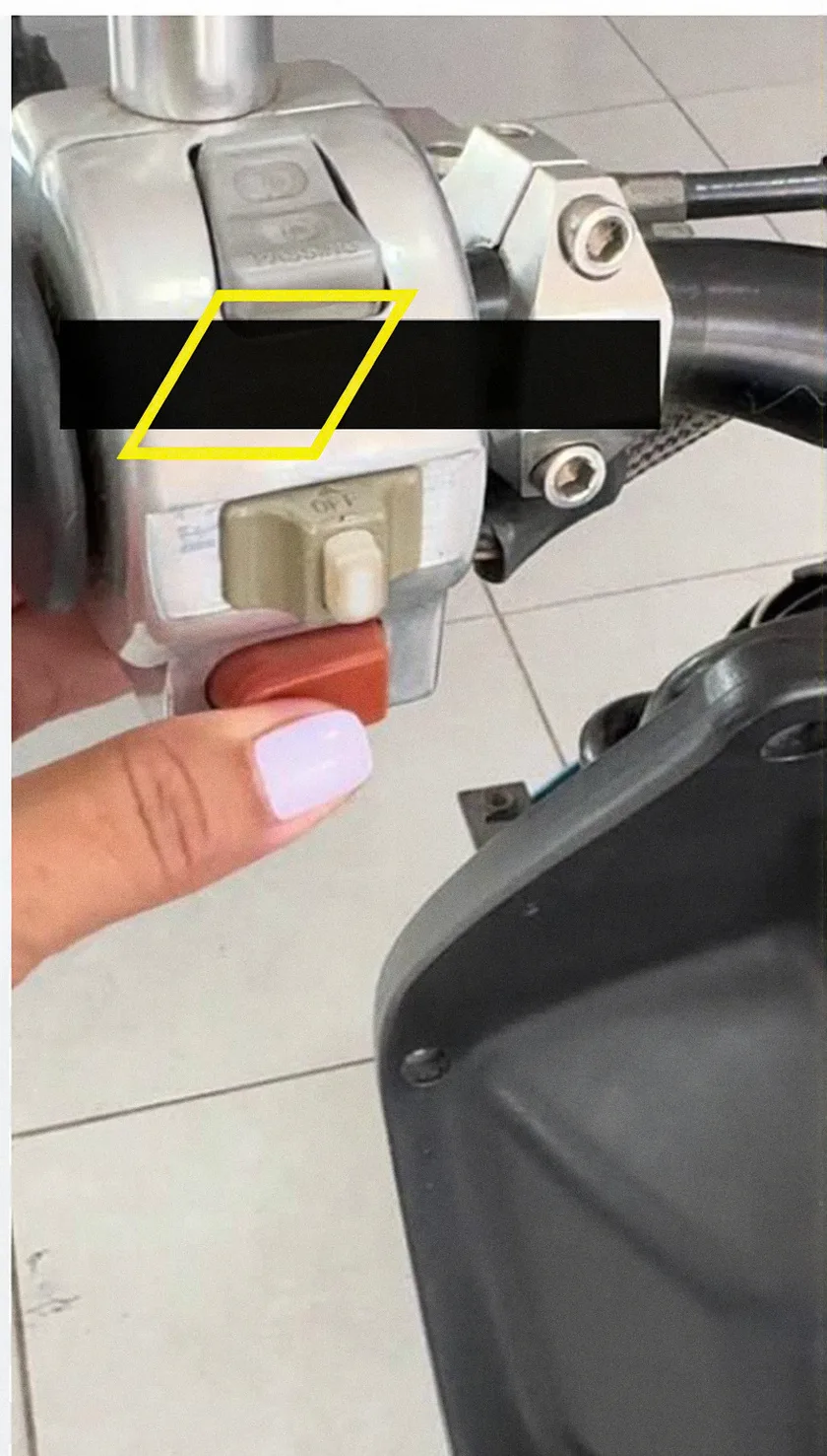 Persona pulsando el avisador acústico eléctrico en el manillar de un ciclomotor