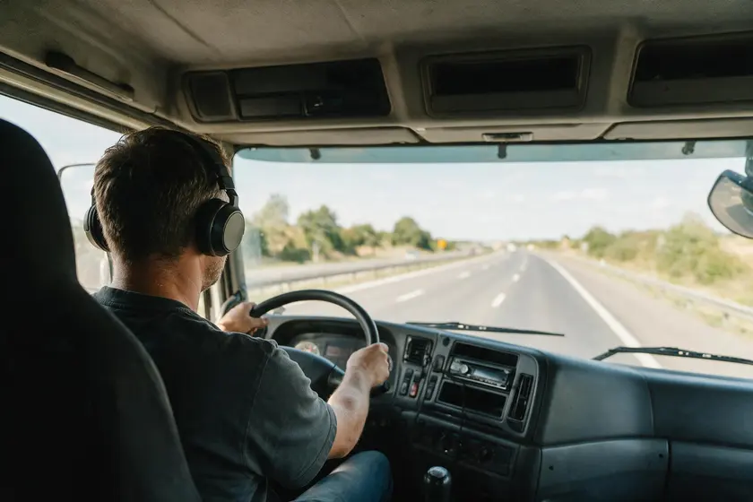Conductor de camión al volante con auriculares puestos