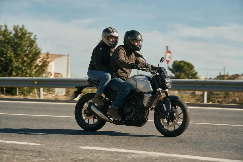 Conductor y pasajero de una motocicleta llevando ambos casco