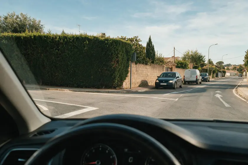 Cruce con la visibilidad tapada por un seto y un muro al girar a la izquierda