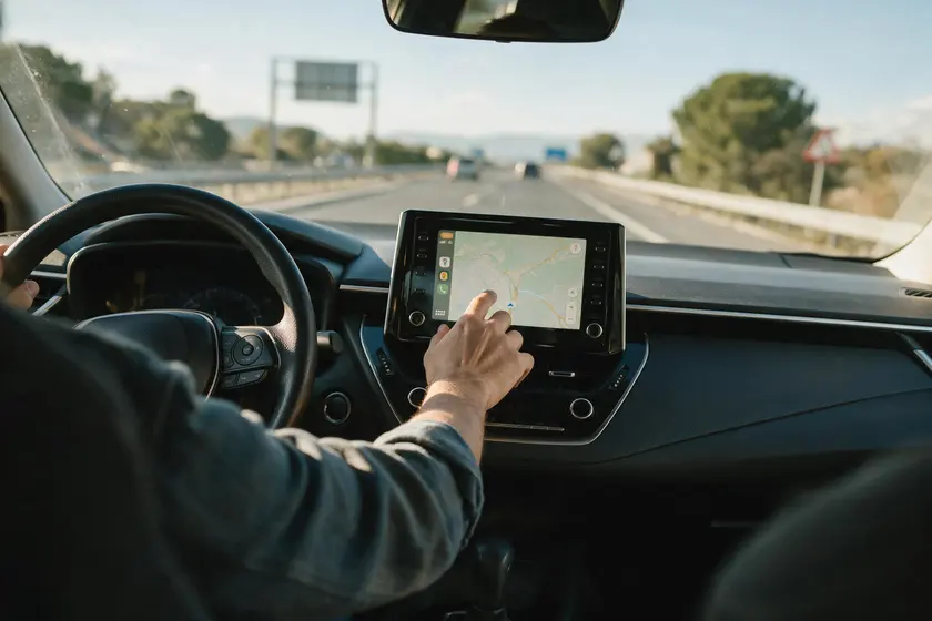 Conductor manipulando la pantalla del navegador mientras conduce