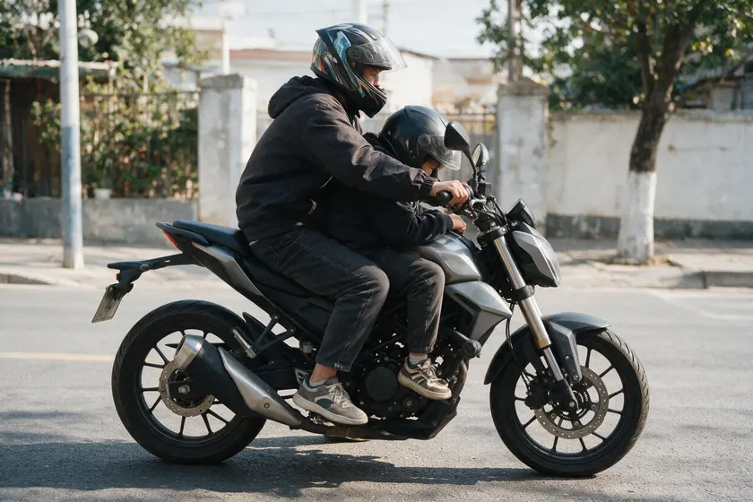 Pasajero de moto colocado incorrectamente entre el conductor y el manillar