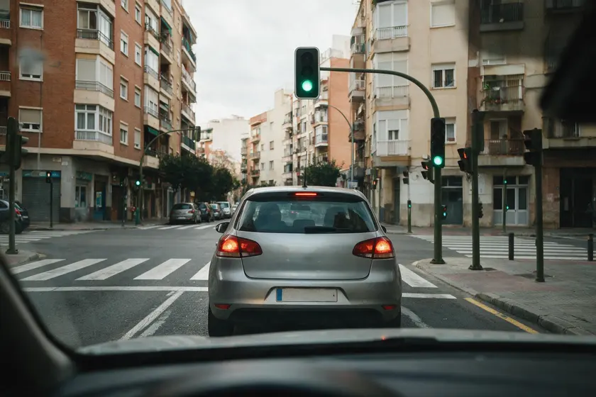 Semáforo que acaba de ponerse verde con un coche todavía detenido delante
