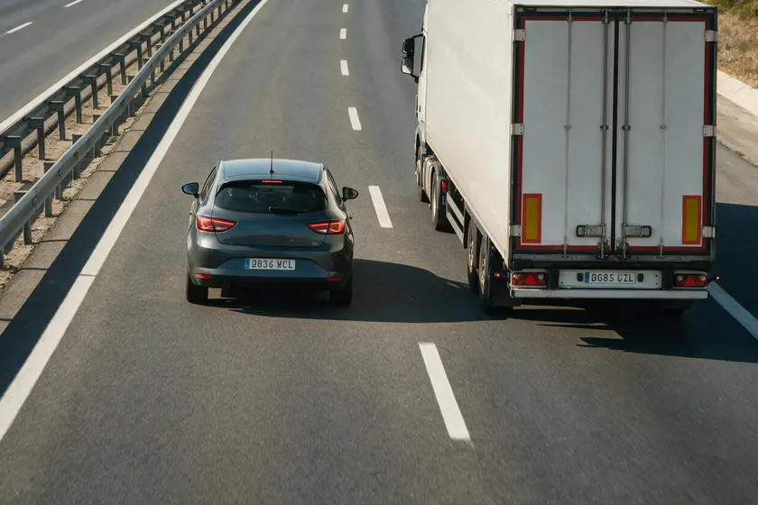 Coche adelantando a un camión en autopista con separación amplia