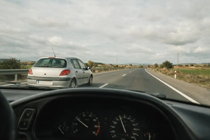 Coche siendo adelantado por otro vehículo en una carretera interurbana