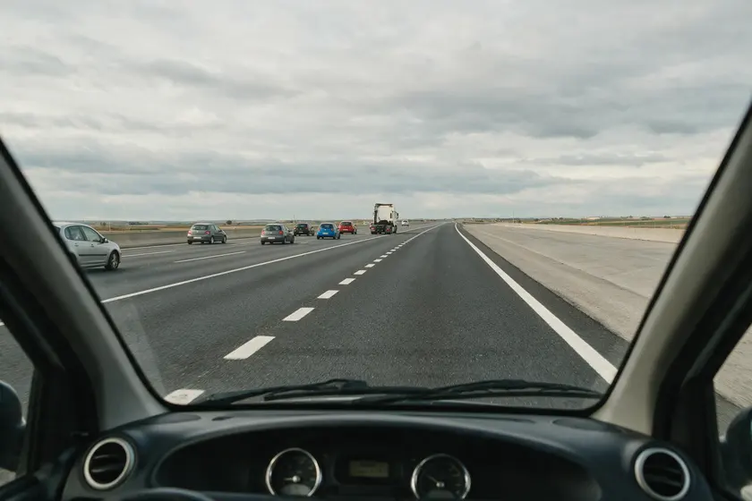 Carril de incorporación a una autovía visto desde el puesto del conductor, junto a la calzada principal con tráfico