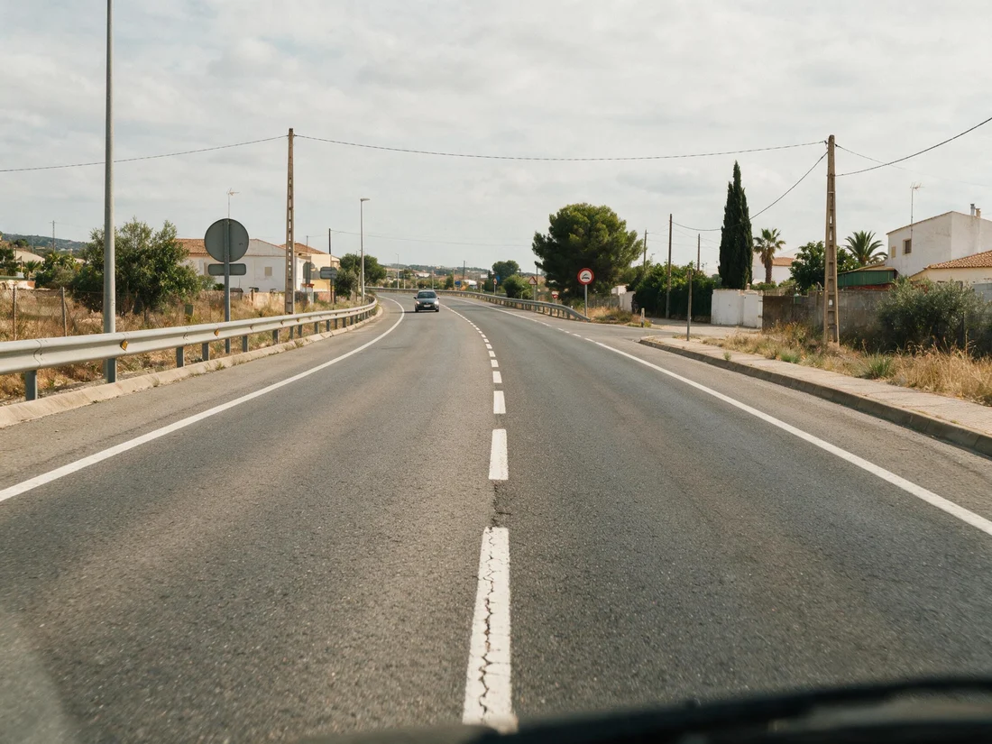 Calzada de doble sentido con dos carriles, uno para cada sentido, separados por una línea discontinua