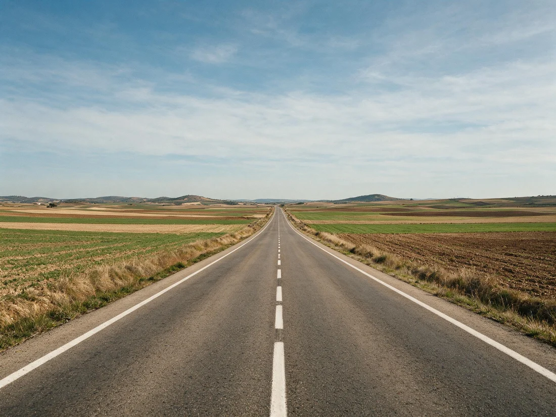 Carretera convencional entre campos, fuera de cualquier población