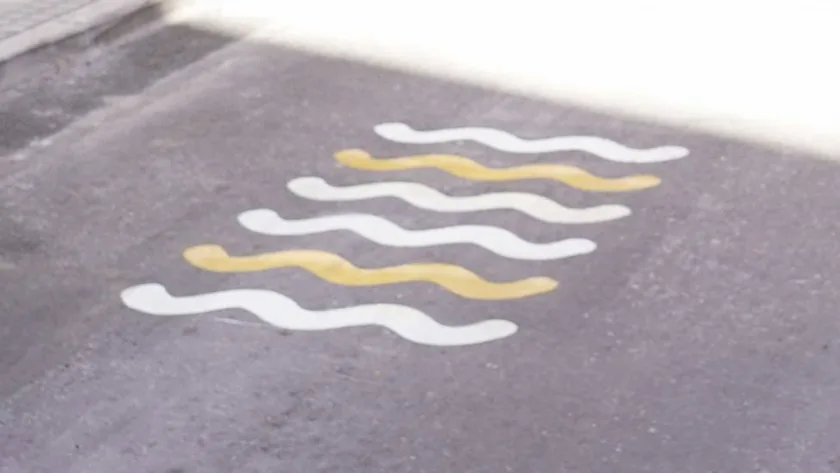 Líneas onduladas blancas y amarillas pintadas sobre el asfalto