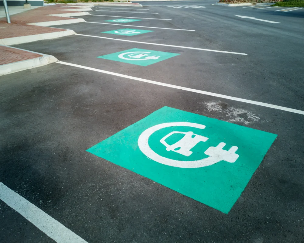 Plaza de estacionamiento con el símbolo de recarga eléctrica pintado en el suelo